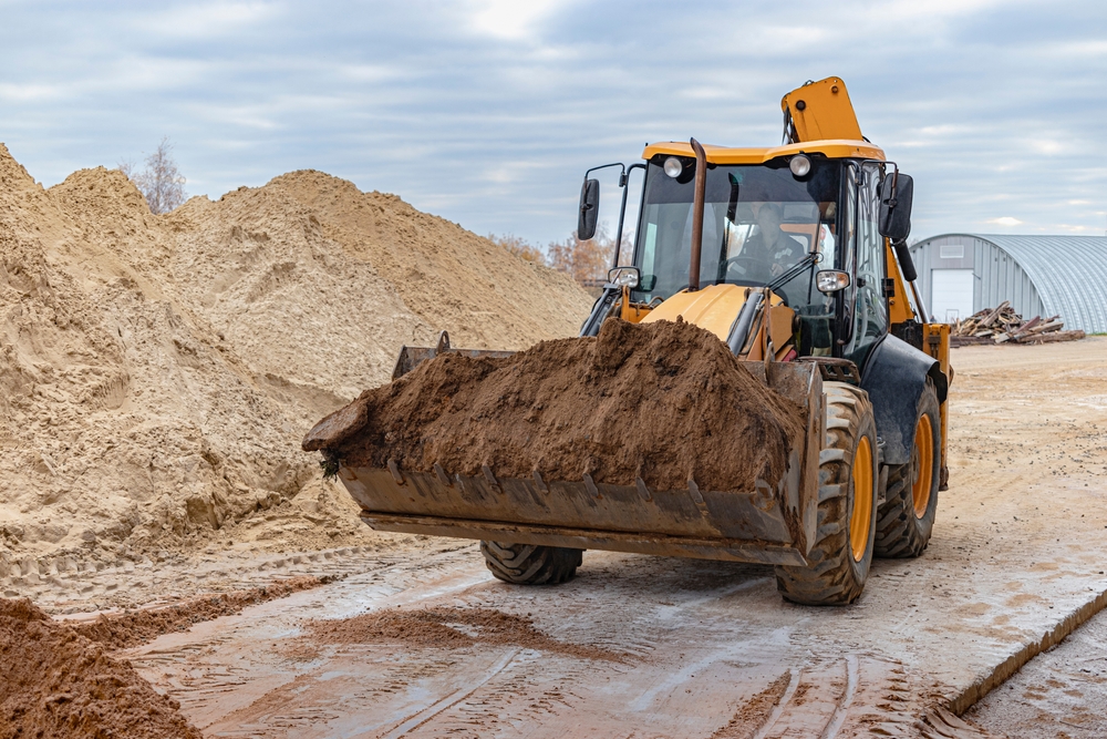 The,Excavator,Backfills,The,Pit,With,The,Front,Bucket.,Moves
